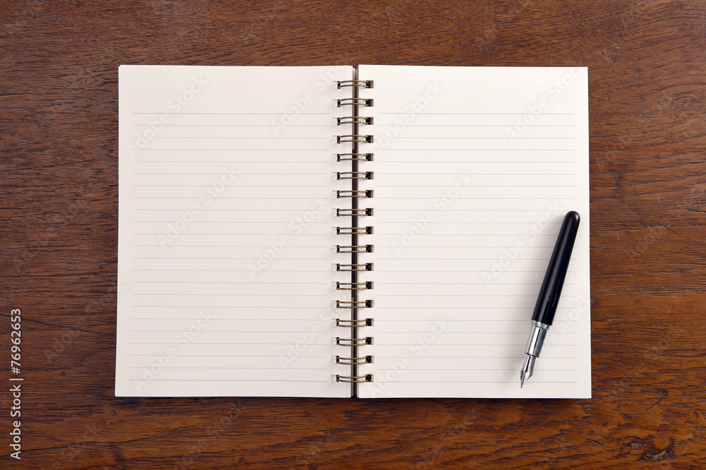 Open notebook and pen on wooden background. Open notebook and pen on wooden background.