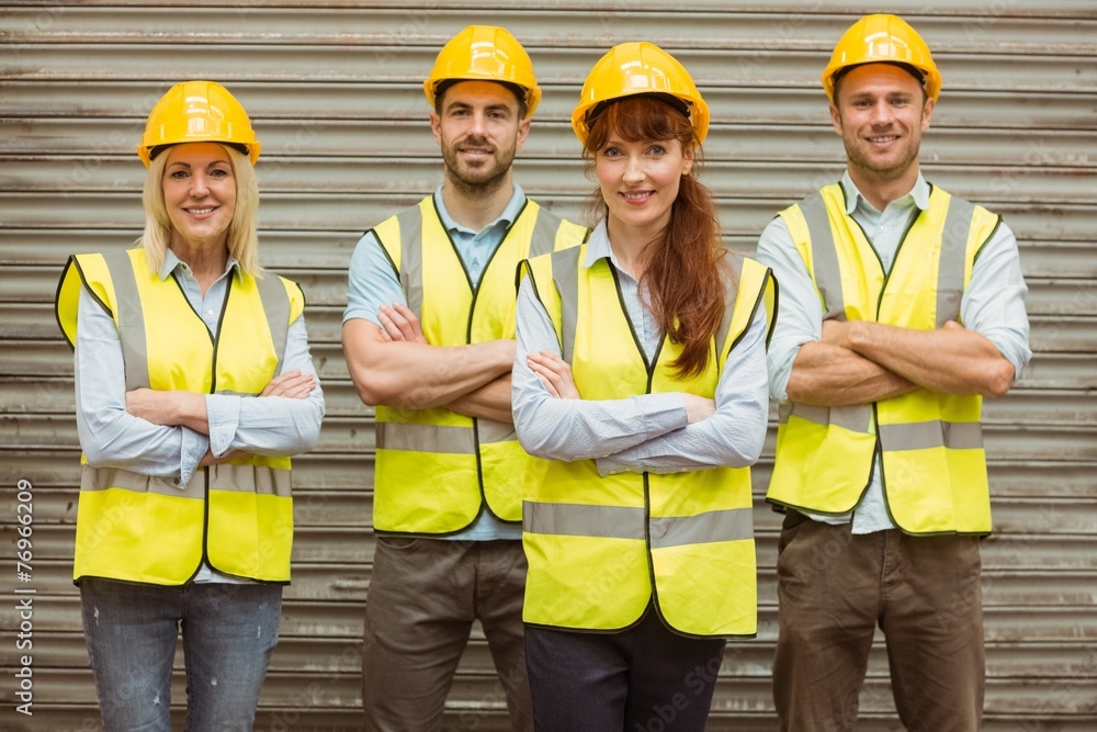 Warehouse team with arms crossed wearing hard hat Warehouse team with arms crossed wearing hard hat