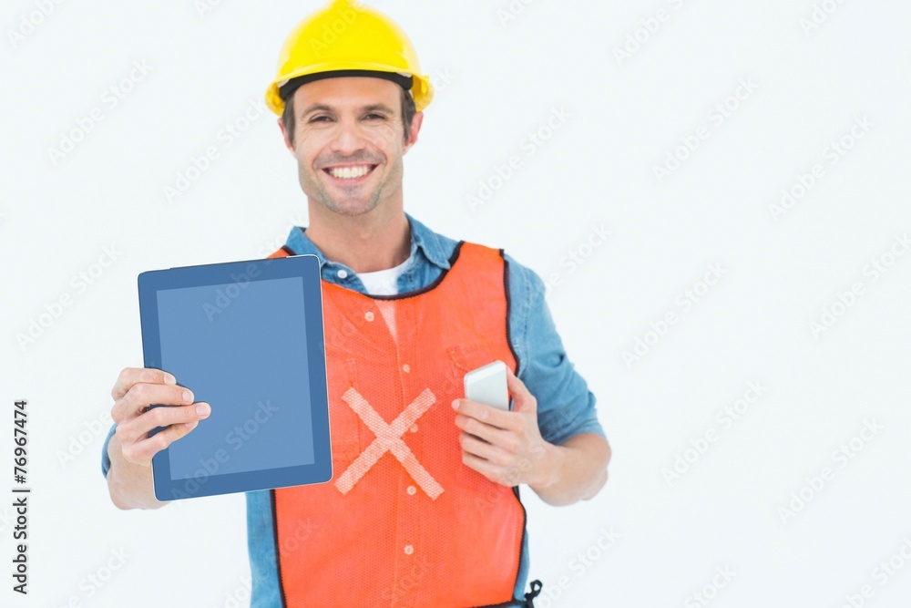 Carpenter holding digital tablet and mobile phone Carpenter holding digital tablet and mobile phone