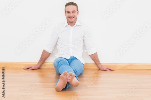 Casual man sitting on floor at home