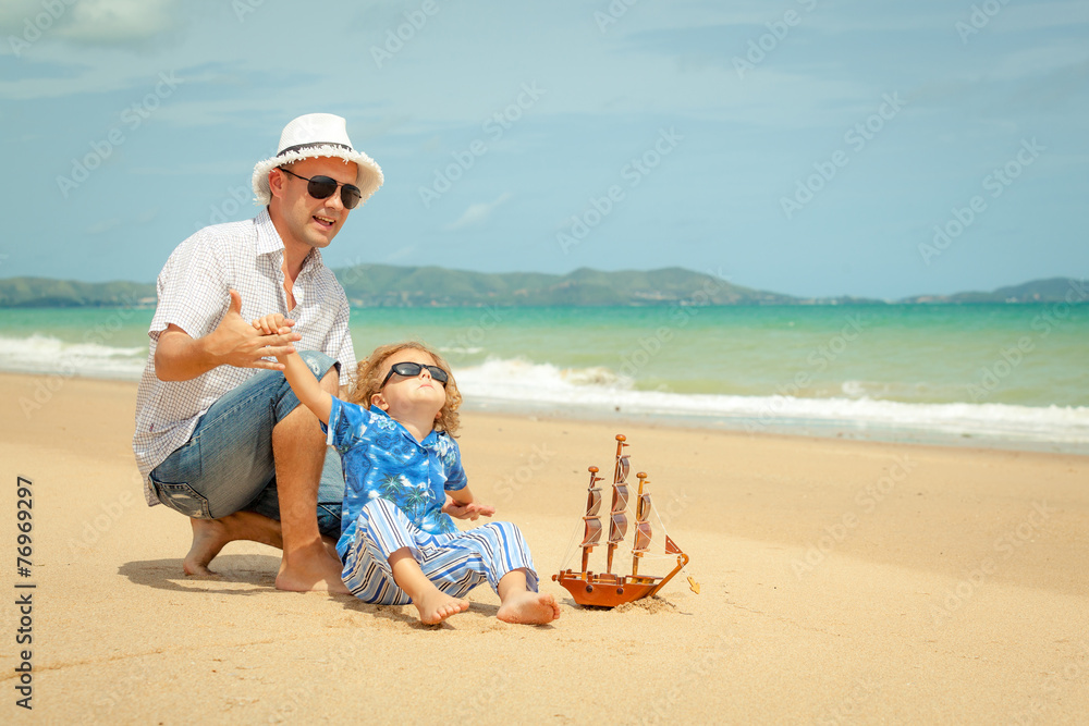 Father and son playing on the beach at the day time.