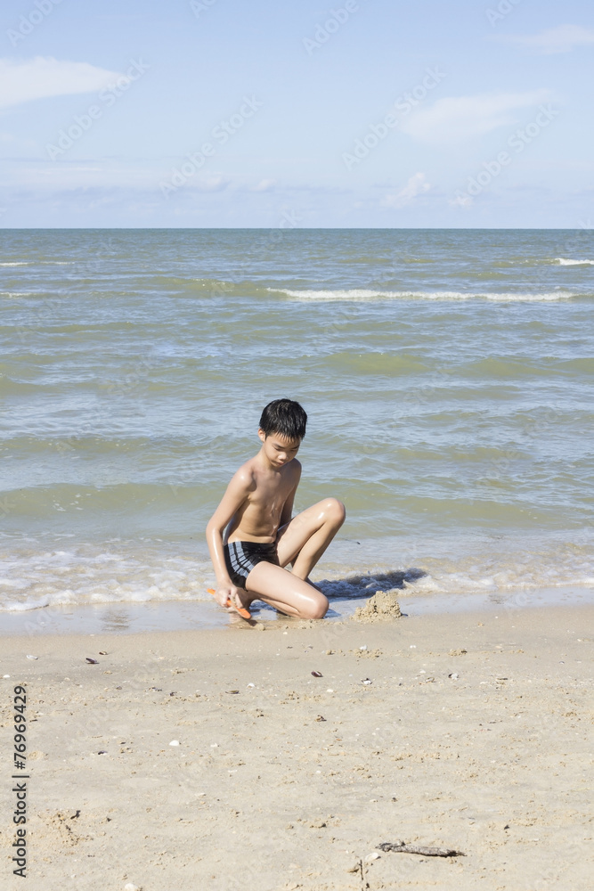 Asian Thai boy playing sand