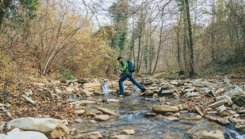 Tableau sur toile Hiker man crossing a creek