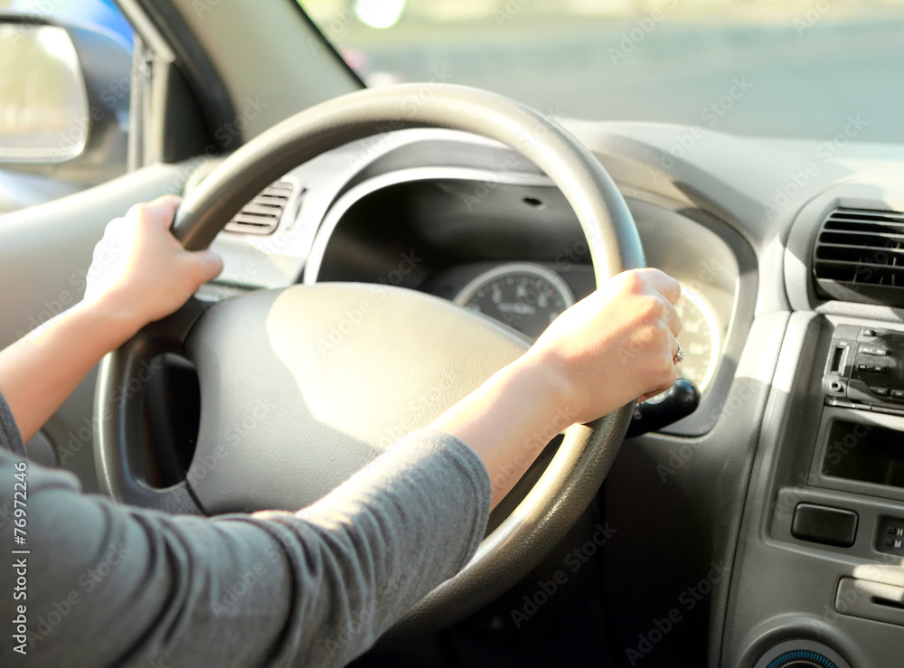 woman with her hand on the wheel steering