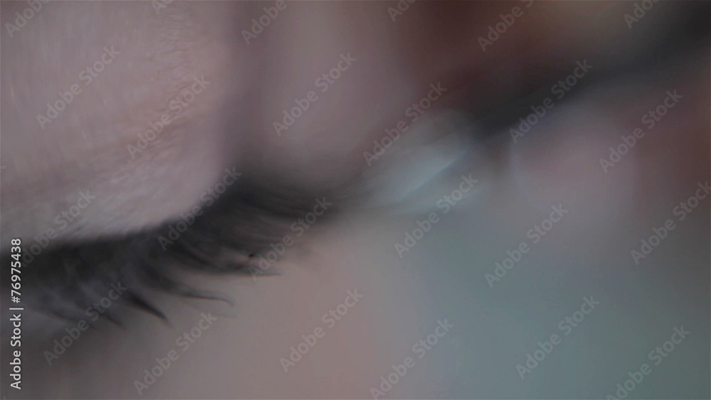 artist applying false eyelashes to the eye of a model. macro artist applying false eyelashes to the eye of a model. macro