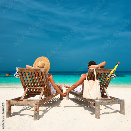 Couple in white relax on a beach at Maldives