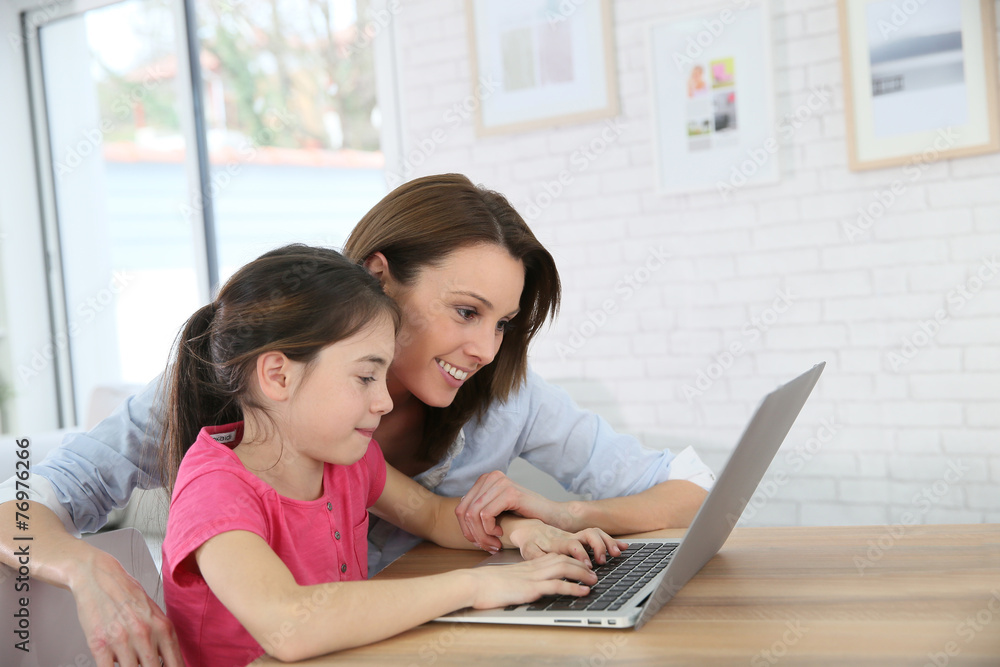 Mother and daughter playing on laptop computer Mother and daughter playing on laptop computer