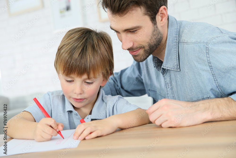 Daddy with little boy making drawings at home Daddy with little boy making drawings at home