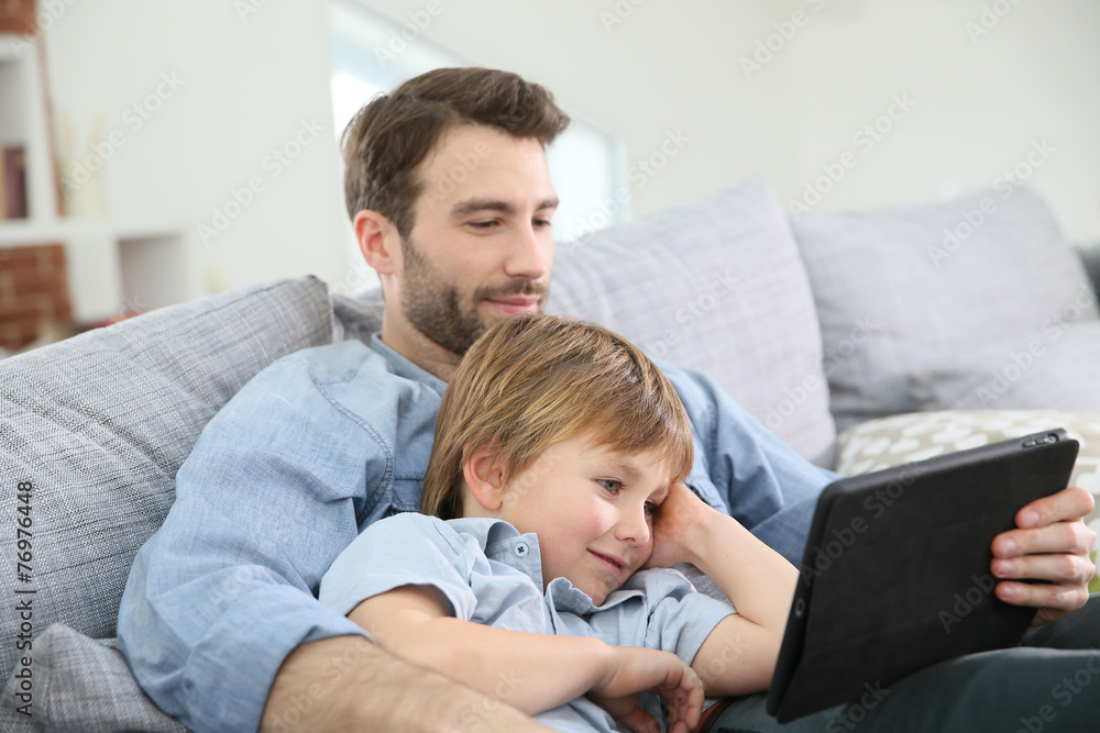 Father with little boy using digital tablet at home Father with little boy using digital tablet at home