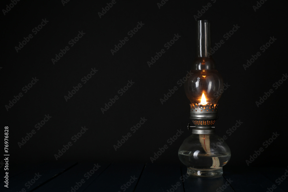 Kerosene lamp on wooden table and dark background Kerosene lamp on wooden table and dark background