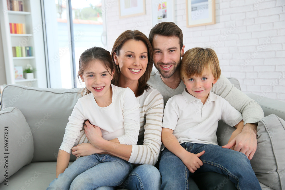 Cheerful family at home sitting in sofa