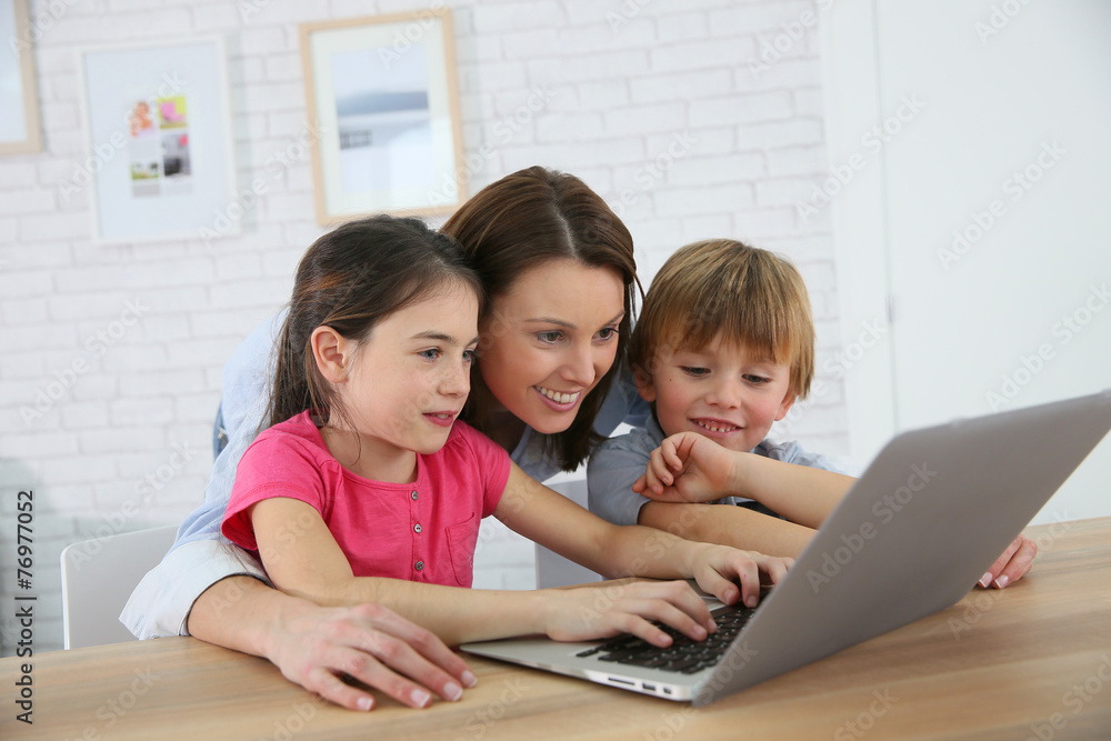 Mother with kids playing on laptop computer Mother with kids playing on laptop computer