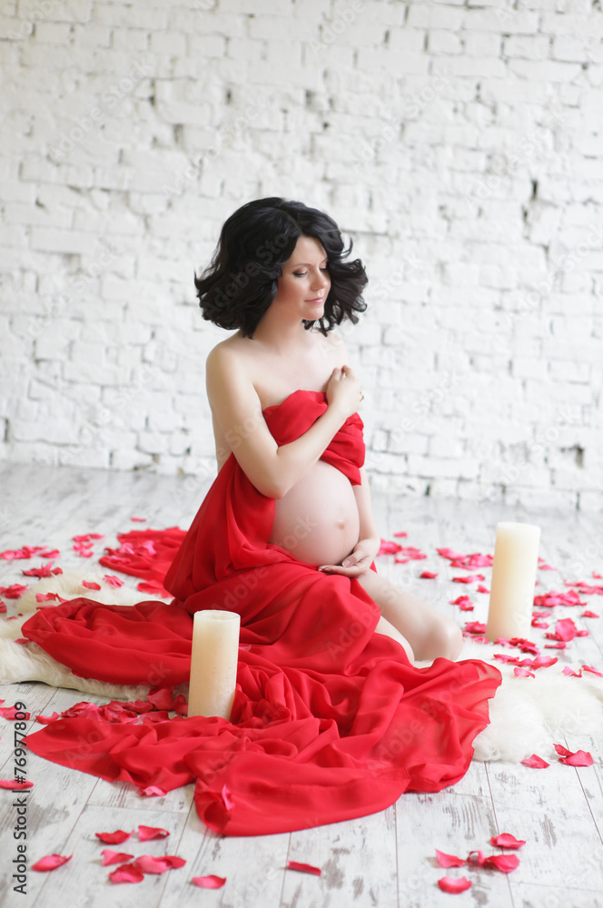 Portrait of a beautiful pregnant woman in red chiffon shawl