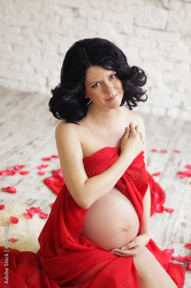 Portrait of a beautiful pregnant woman in red chiffon shawl