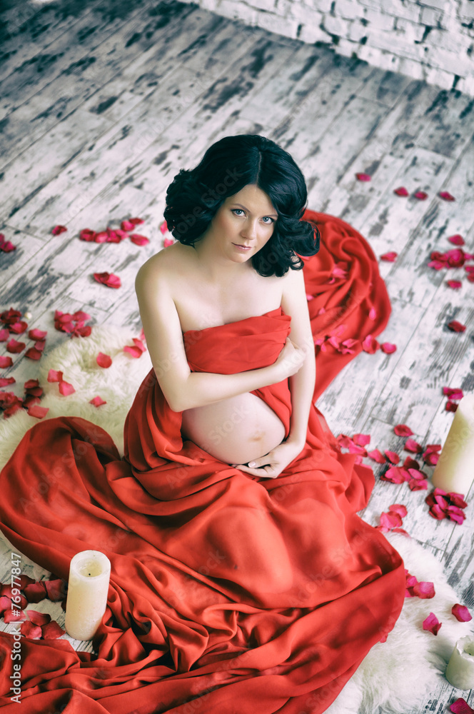 Portrait of a beautiful pregnant woman in red chiffon shawl