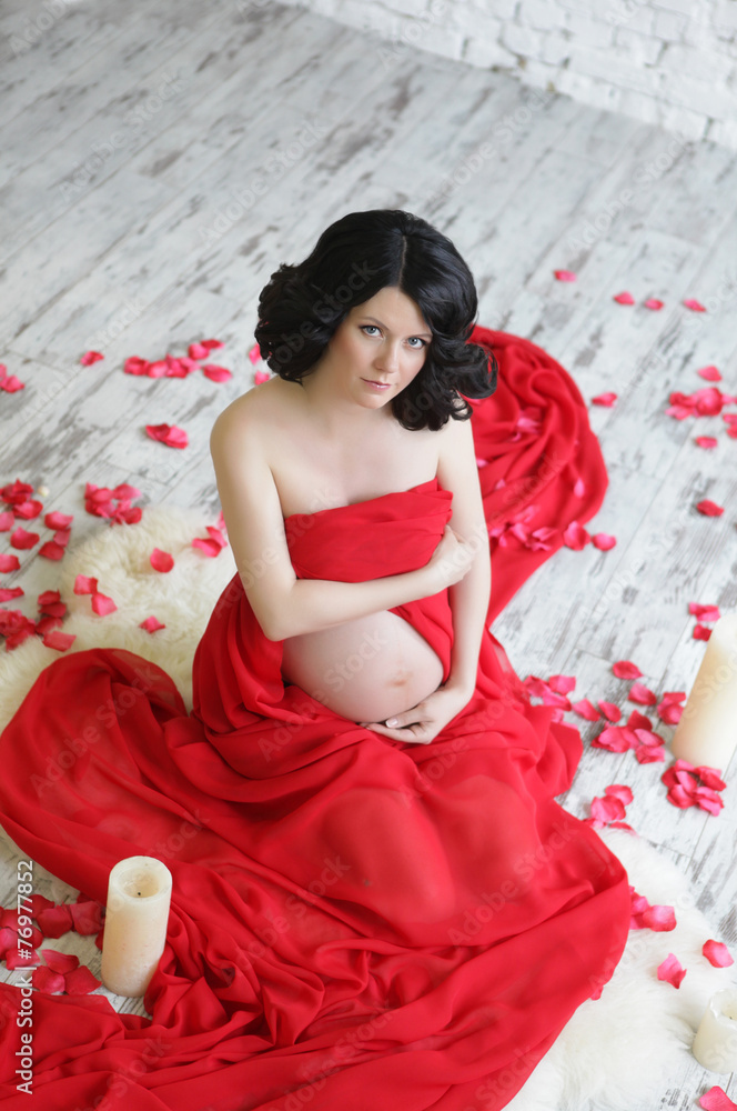 Portrait of a beautiful pregnant woman in red chiffon shawl