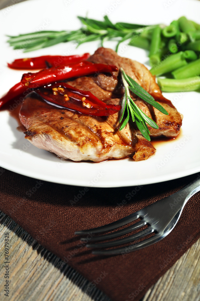 Steak with vegetables on plate on table close up Steak with vegetables on plate on table close up