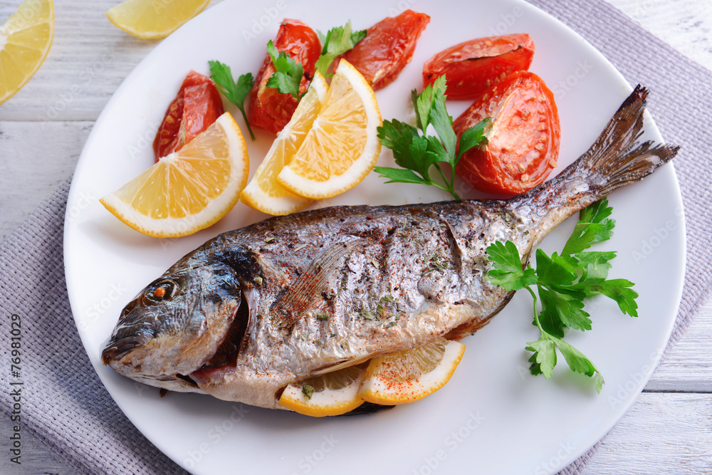 Tasty baked fish on table close-up Tasty baked fish on table close-up