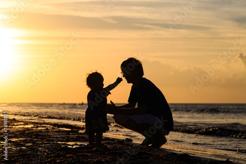 Father and little daughter silhouettes at sunset