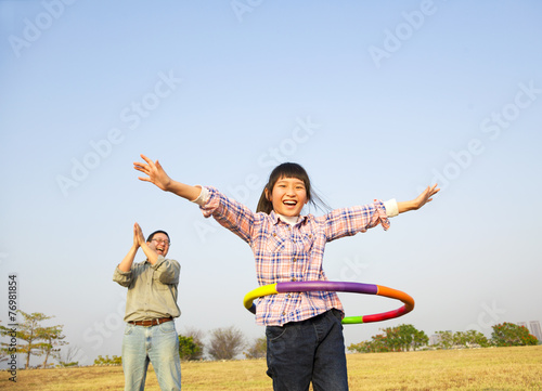 happy kid playing hula hoops outdoors