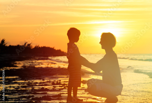 father and son holding hands at sunset