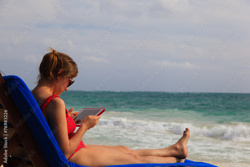 woman with touch pad on summer beach