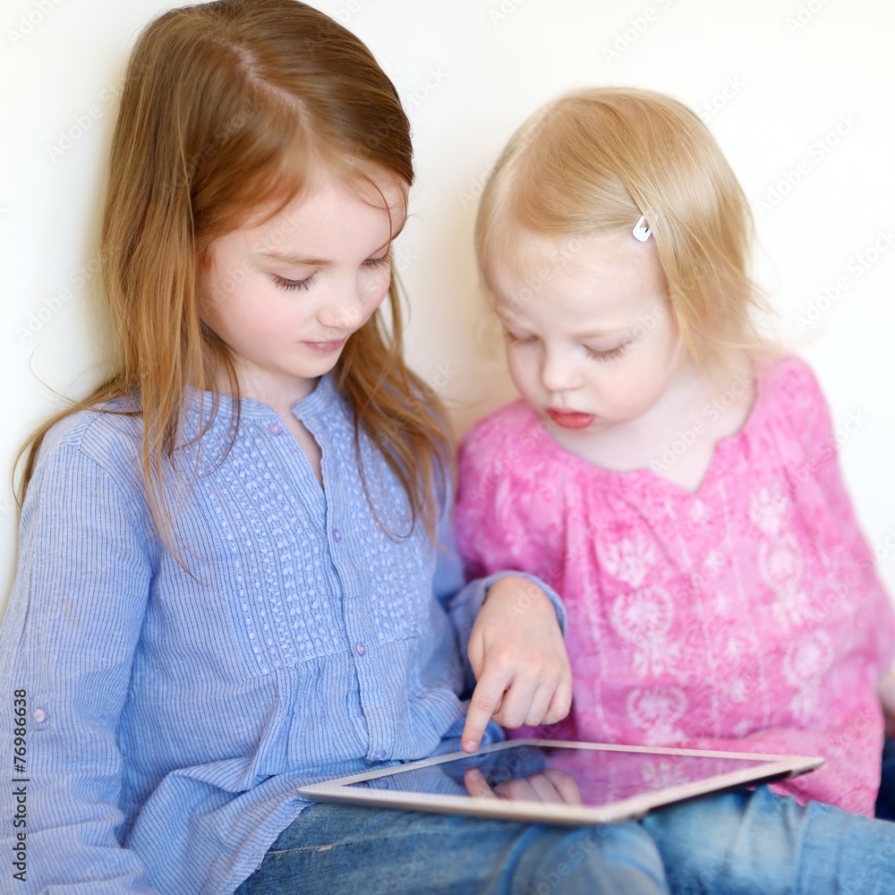 Two children playing with a tablet at home Two children playing with a tablet at home