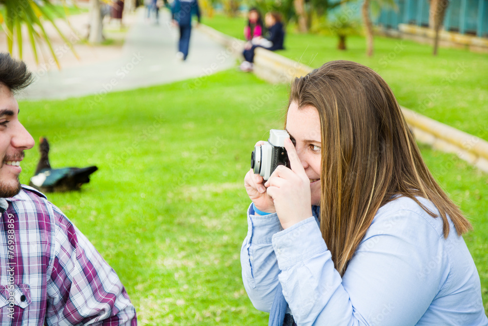 Young woman doing a photo to her boyfriend in the park Young woman doing a photo to her boyfriend in the park
