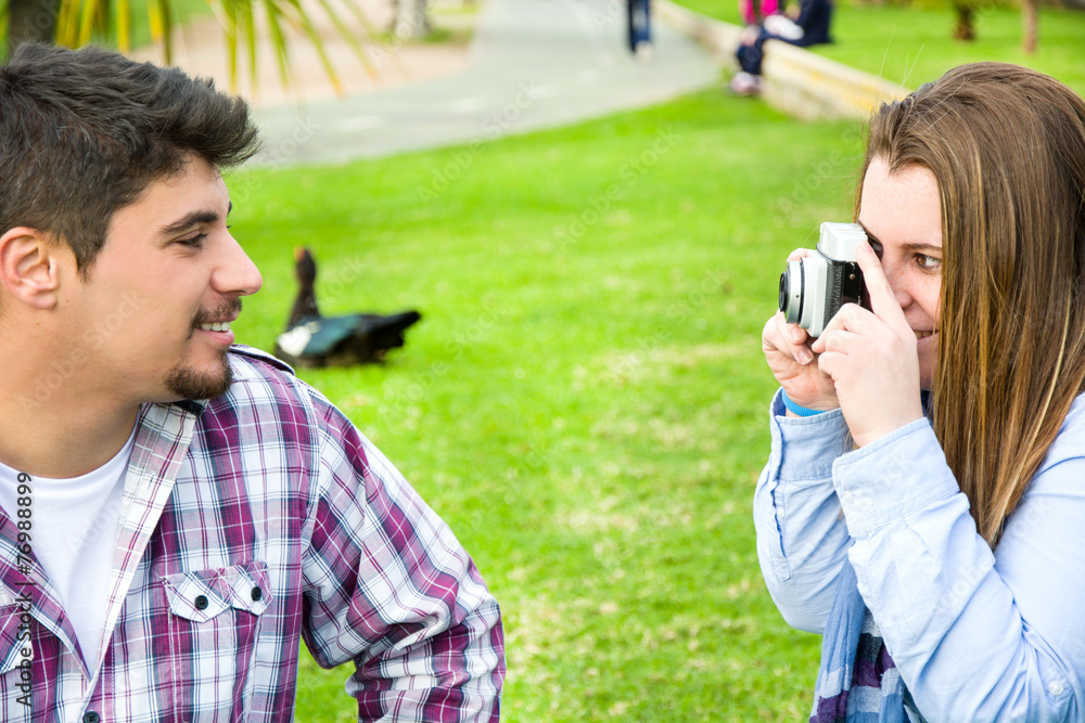 Young woman doing a photo to her boyfriend in the park Young woman doing a photo to her boyfriend in the park