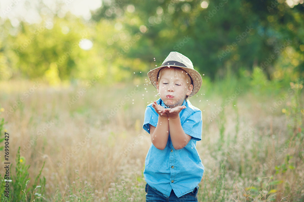 Happy child blowing dandelion
