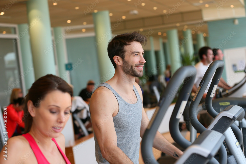 Couple doing cardio training program in fitness center Couple doing cardio training program in fitness center