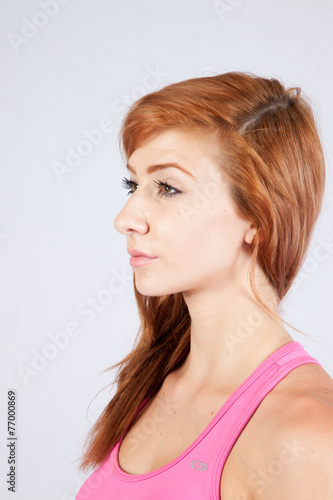 Redhead woman in exercise outfit, looking focused