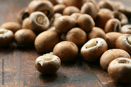 Foto Braune Champignons - Pilze auf einem Holzbrett, gesunde vegane pflanzenbeasierte