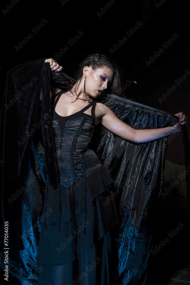 Sensual young girl dressed in black coat with gothic style