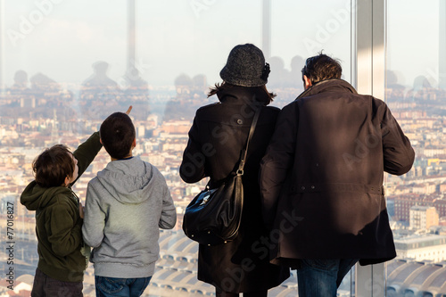 Famiglia osserva la città dalla finestra del grattacielo