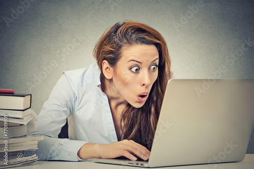 shocked business woman sitting in front of laptop computer