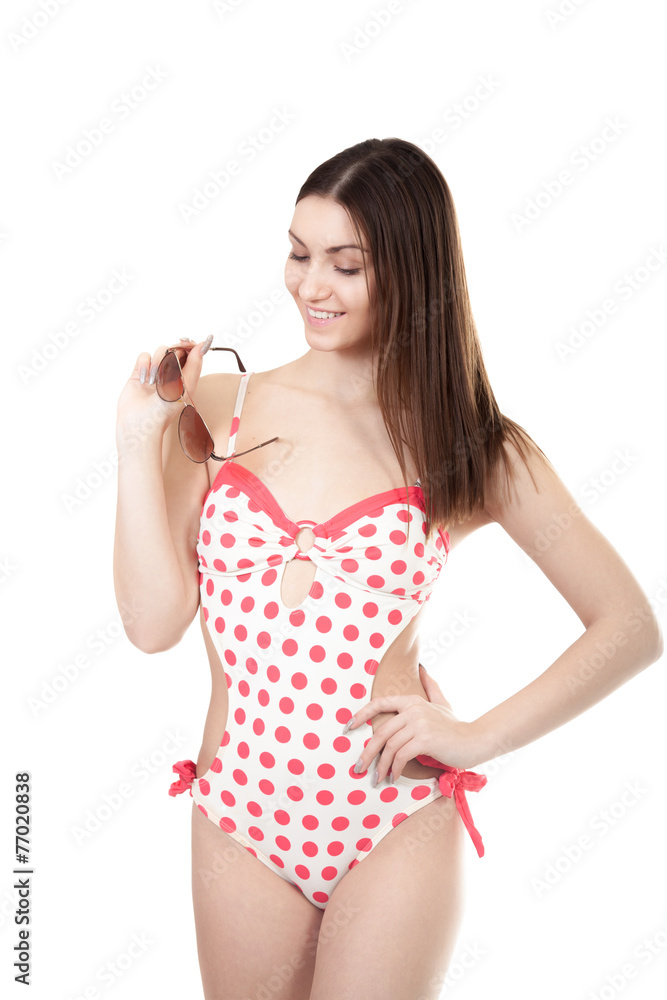 Smiling young woman in swimsuit holding sun glasses, isolated Smiling young woman in swimsuit holding sun glasses, isolated
