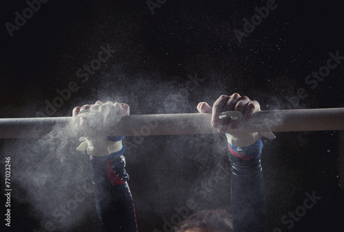 Photo hands of gymnast with chalk on uneven bars
