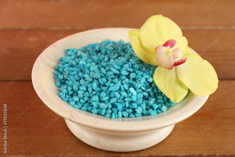 Bowl with sea salt and orchid on wooden background Bowl with sea salt and orchid on wooden background