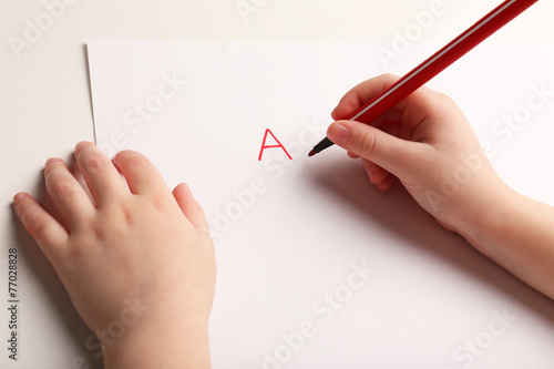 Child hand writing letters
