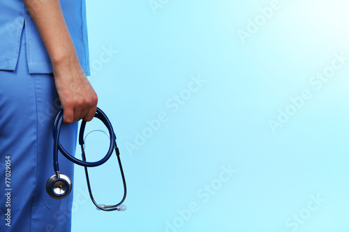 Doctor with stethoscope on blue background