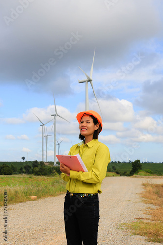Woman engineer or architect with white safety hat and wind turbi