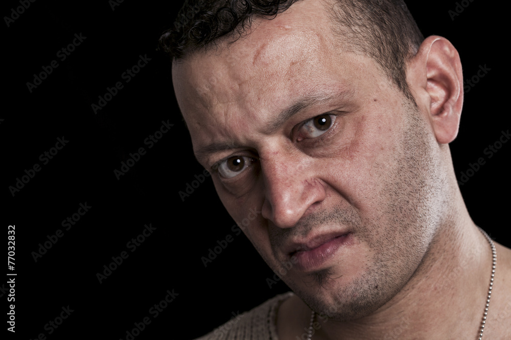 Portrait of man with frown looking at camera closeup Portrait of man with frown looking at camera closeup