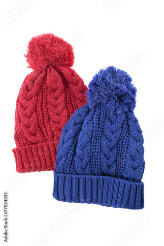Two chunky knit warm winter bobble knit hats ski clothing isolated white background photo