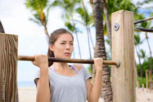 Fitness woman exercising on chin-up bar