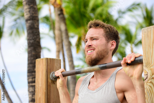 Crossfit man working out pull-ups on chin-up bar