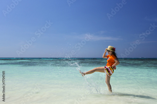 Beautiful woman kicking sea water