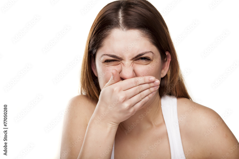 disgusting young woman checking her breath with her hand disgusting young woman checking her breath with her hand