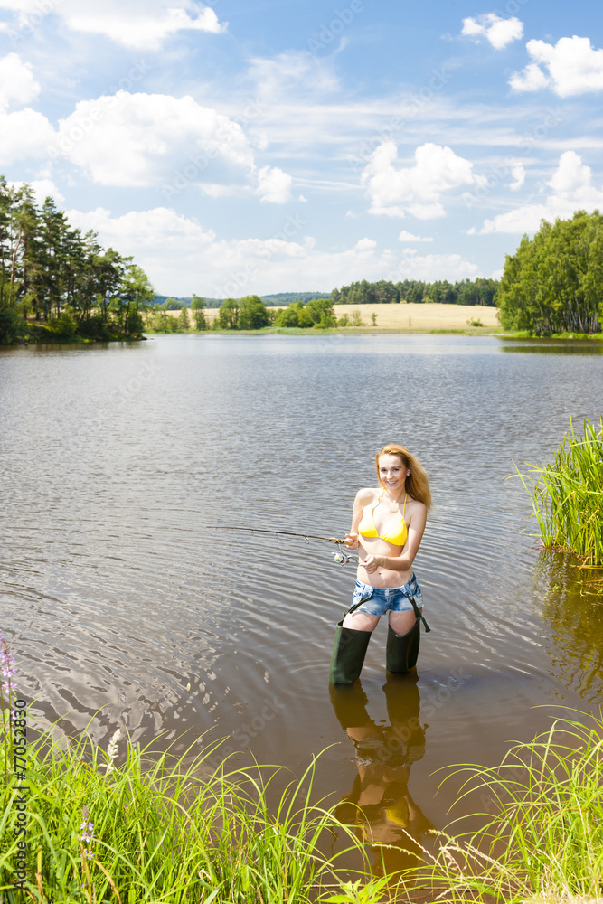 young woman fishing in pond during summer young woman fishing in pond during summer