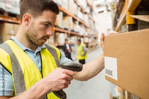 Warehouse worker scanning barcodes on boxes